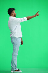 A man in a white shirt, on a green background, in full height, shows a forbidding sign, profile