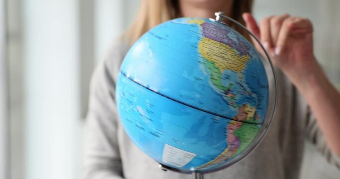 Woman travel agent spinning globe closeup 4k movie slow motion