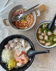 boiled rice clear soup with shrimp in a ceramic bowl on wooden table. homemade style food concept.
