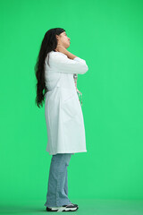 A female doctor, on a green background, full-length, tired, profile