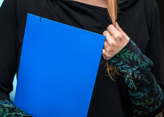 Zawstydzona kobieta trzyma się za włosy podczas formalnej rozmowy z dokumentami w dłoni  - obrazy, fototapety, plakaty