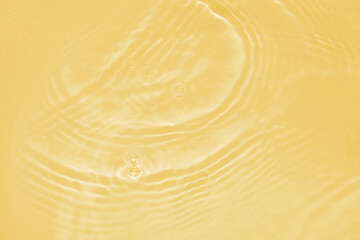 The surface of the water dripped and rippled in the basin. The transparent yellow water surface is...