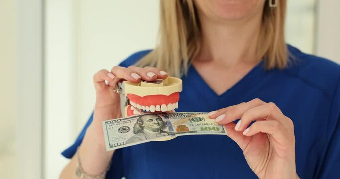 Dentist bitting dollars money with human artificial jaws closeup 4k movie slow motion