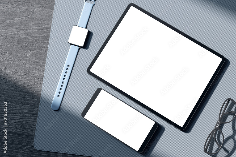 Poster top view of empty white tablet and cellphone screen, digital watch, pen and glasses on gray wooden t