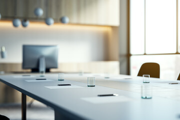 Close up of white table with items in modern conference room. Blurry interior background. Workplace...