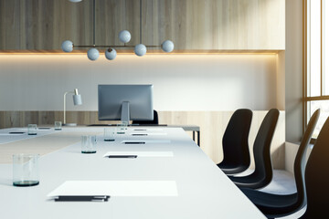 Close up of white desk with objects in modern conference room. Blurry interior background. Workplace concept. 3D Rendering.