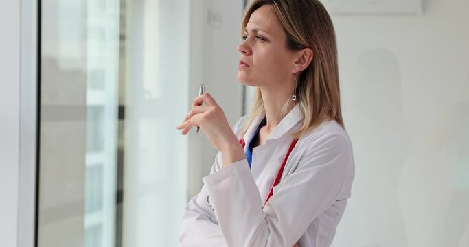 Pensive woman doctor thinking about examining patient in clinic 4k movie slow motion