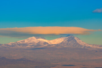 Flat saucer-shaped cloud over the peaks of Aragats, Armenia