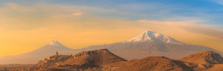 Wide angle view of sunrise with Ararat mountains and the ancient Khor Virap monastery at fall. Travel destination Armenia