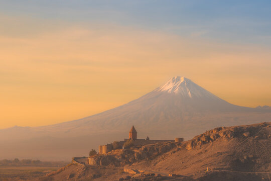 Closeup of Ararat mountains with the old Khor Virap monastery at fall sunrise and orange sky. Travel destination Armenia