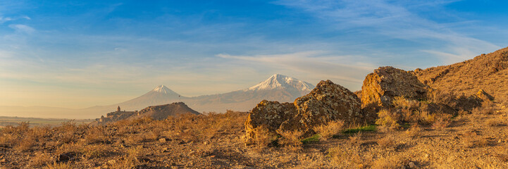 Wide angle panoramic view of close-up of Ararat mountains with the Khor Virap monastery at fall sunrise. Travel destination Armenia - obrazy, fototapety, plakaty