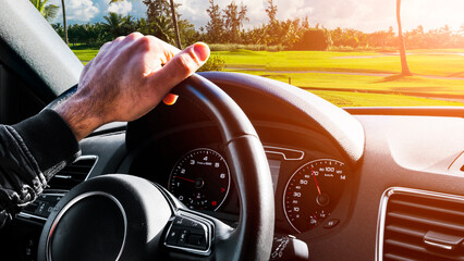 Male hands holding car steering wheel. Hands on steering wheel of a car driving. Young Man driving...