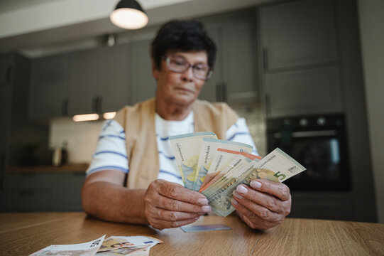 Senior woman counting currency at home