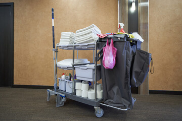 A hotel maid cart with cleaning supplies, clean towels and bedclothes © pridannikov