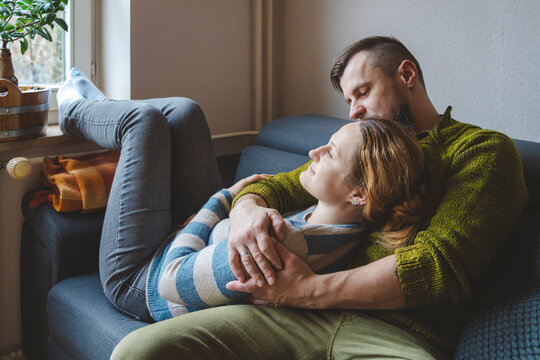 Man embracing woman on sofa at home