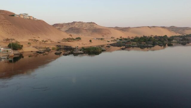 Low Aerial Drone shot of Nile River and Desert Mountain in Aswan, Egypt
