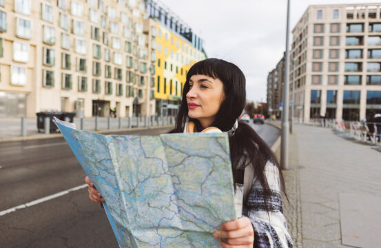Woman with map exploring city on weekend