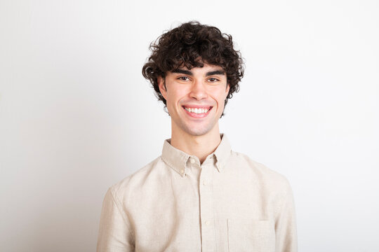 Smiling man with curly hair wearing shirt against white background
