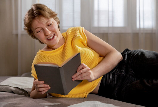 Happy Woman Reading Book At Home