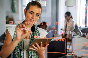 Female coach making notes of information during workflow planning strategy for startup project