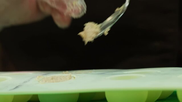 Chef molds pate into spherical shapes using silicone mold. Man offers flawless and decorative addition to upscale molecular dish
