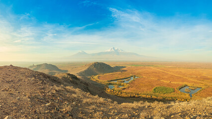 Wide angle top hill panoramic view of sunrise with closeup of Ararat mountains with the Khor Virap monastery at fall. Travel destination Armenia
