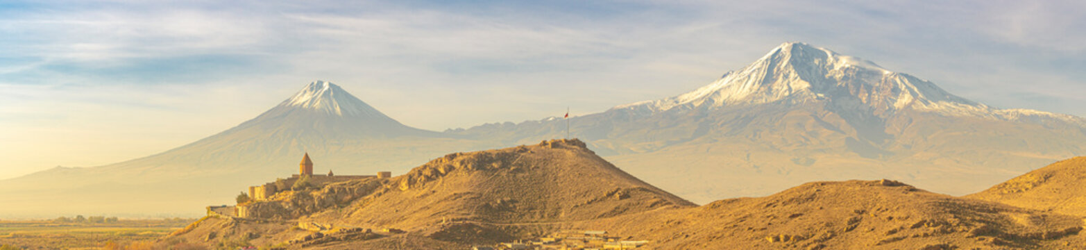 Wide angle panoramic view of sunrise over Ararat mountains with the Khor Virap monastery at fall. Travel destination Armenia
