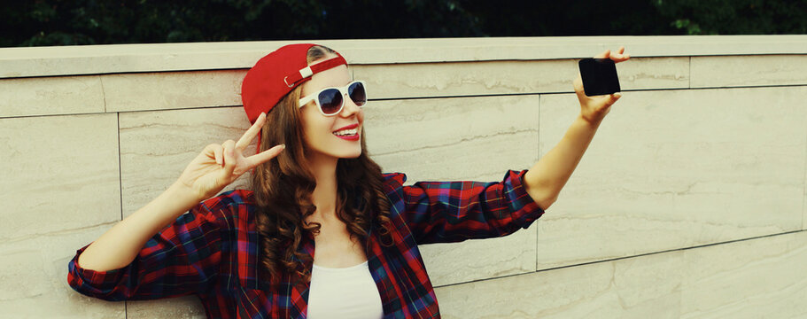 Portrait of teenager girl taking selfie with mobile phone in the city