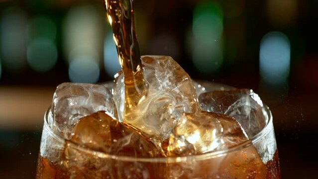 Super slow motion of pouring cola into glass with speed motion. Filmed on high speed cinema camera, 1000 fps. Placed on high speed cine bot. Bar with bottles on background.