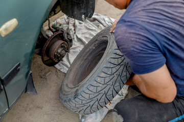 Man changing a tyre after a breakdown in a village near Soroca, Moldova
