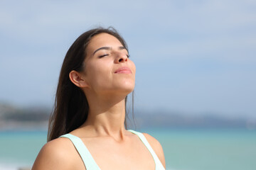 Satisfied woman breathing on the beach