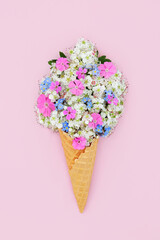Surreal hawthorn blossom, forget me not and rose campion flower ice cream cone concept. Fun edible food art for logo, gift tag, birthday, mothers day, holiday vacation on pink background.