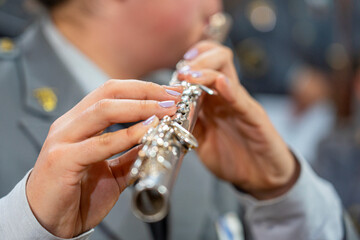 ransverse flute to be played by a woman in a gray military uniform.