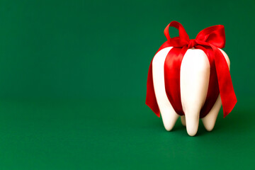Large white modal molar is tied with a red ribbon with a bow.
