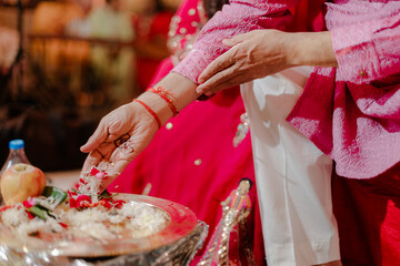 Indian man and woman, having a traditional Hindu ceremony with coconut leaves during wedding