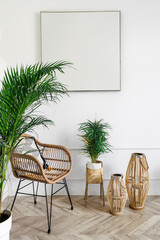 Vertical shot of rattan armchair under picture with copy space on white wall