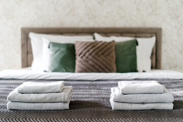Clean bath towels neatly folded on comfort double bed in hotel room