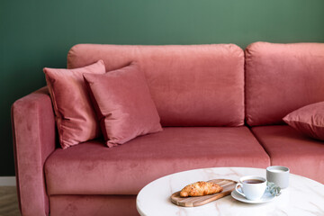 Selective focus on bakery and cup on coffee table in living room