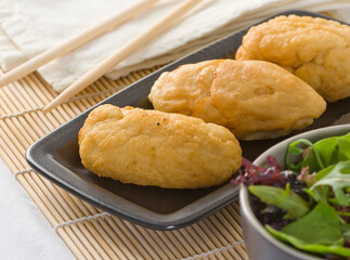 Chinese bread on black plate with salad. Fried dough bar.