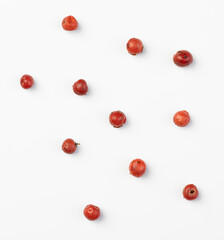 Red peppercorn seeds isolated on a white background.