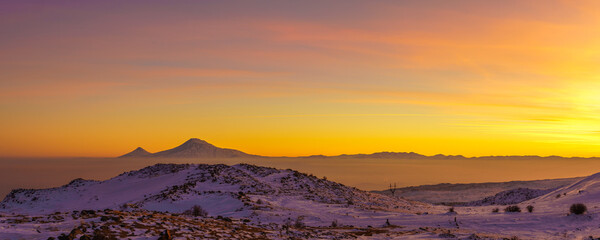 Wide angle view on sunset over the Ararat mountains at winter as seen from the Aragats. Travel destination Armenia