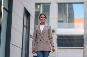 Beautiful business woman in suit near modern office building.