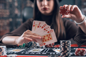 Young female player make bet, raise chips in poker game, change to win