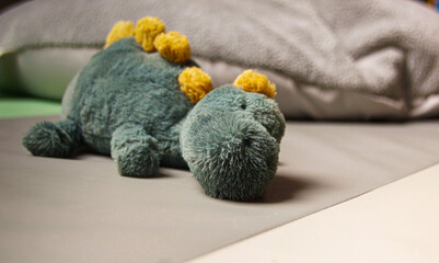 Green Dino cuddly toy lying on the floor