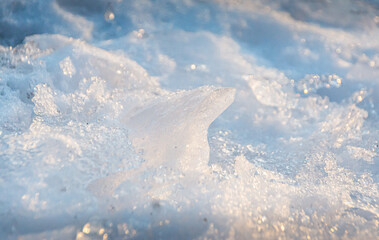 Frozen ground with white ice and reflections of the sun. Usable as background with space for text