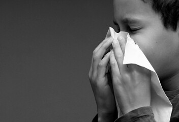 asthmatic breathing problems catching the flu child blowing nose after having a cold with grey background with people stock photo - obrazy, fototapety, plakaty