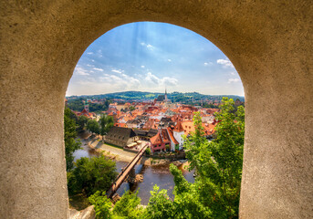 The Beautiful Old City of Cesky Krumlov in the Czech Republic, as Seen through a Window in the Walls with the Path Leading to the Famous Castle, with the Vltava River and the Saint Vitus Church Domina - obrazy, fototapety, plakaty