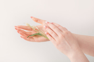 Naklejka premium female hands with beautiful long nails with flowers on white background