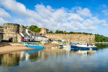 Conwy, North Wales - Boats tied up along the River Conwy estuary and cottages built against the...