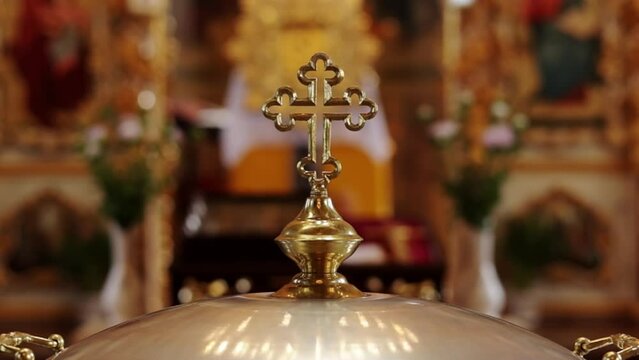 Aluminium church font, large bowl, with golden cross and saint water for the baptism of babies in Orthodox Church temple, Christening ceremony. Concept of rituals, sacraments of the Christian religion